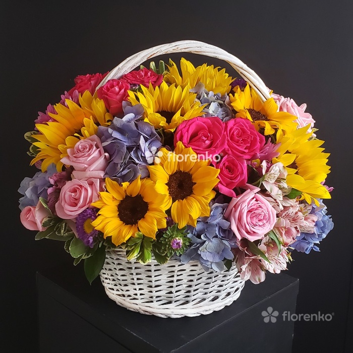 Girasoles, rosas, hortensias azules, astromelias en canasta vintage