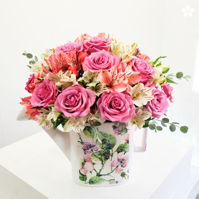 Jardinera con detalles pintados y sobre ella rosas premium, astromelia
