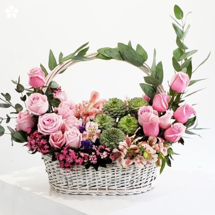 Estilizada canasta cubierta de rosas y suculentas