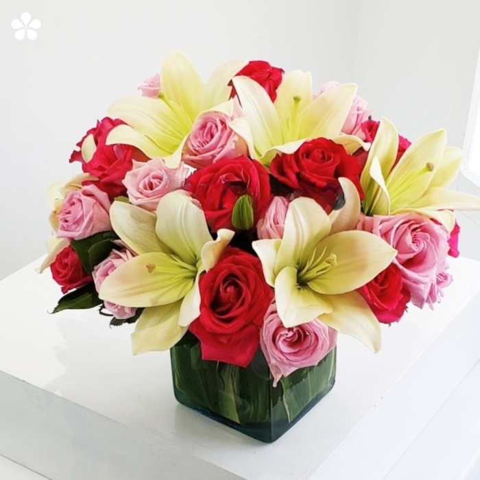 Rosas y lilis en florero de vidrio