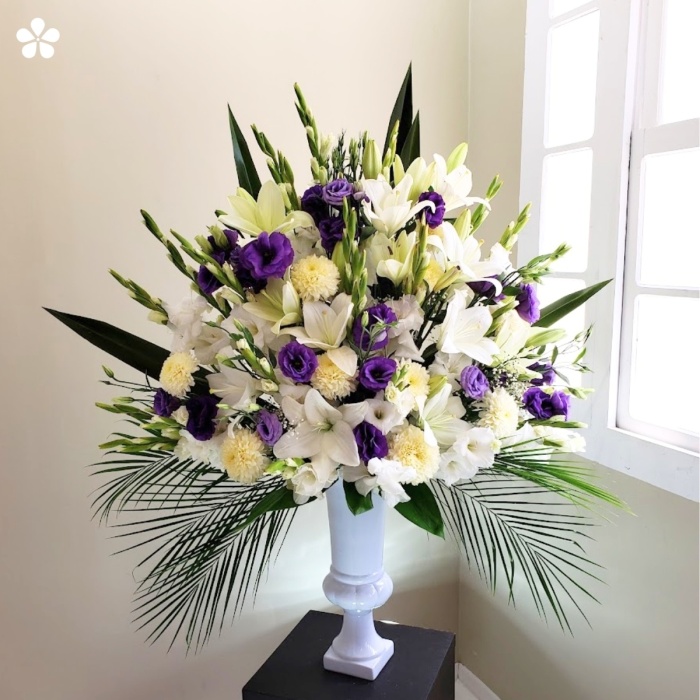 Elegante florero de lilis gladiolas y lisiantus en copa alta