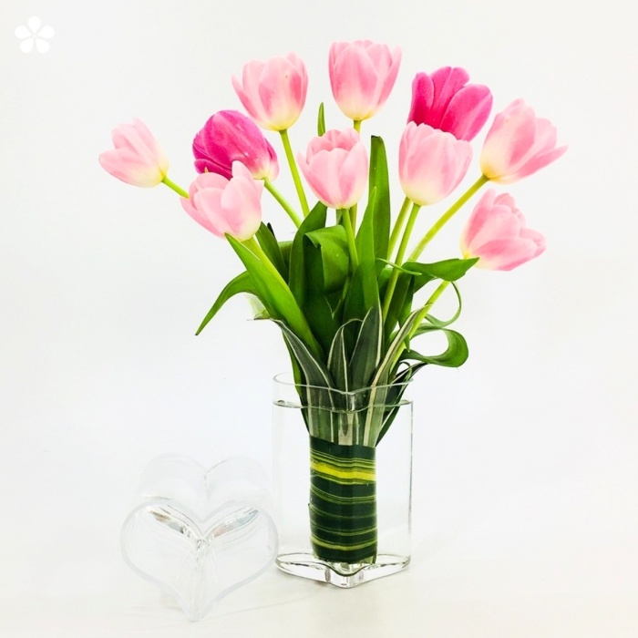 Tulipanes rosas en base de corazón de cristal